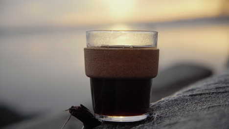 Kaffee-In-Einer-Nachhaltigen-Tasse-Aus-Glas,-Die-Morgens-Bei-Sonnenaufgang-Auf-Einem-Baum-Steht
