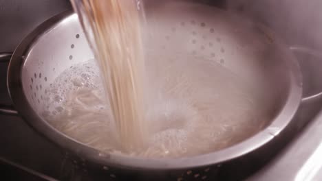 Pouring-Noodles-and-Boiling-Water-into-Strainer,-Cooking-Japanese-Food