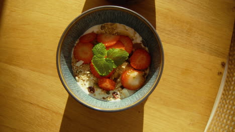 Top-Shot-Yogurt-with-homemade-granola-and-strawberries-decorated-with-mint-in-a-beautiful-bowl