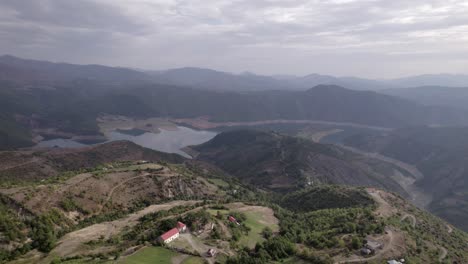 Video-De-Dron-Frontal-En-&quot;hora-Dorada&quot;-Avanzando-Sobre-Las-Montañas-De-Sh22-En-Albania,-Sobre-El-Pueblo-De-Va-Spas-Y-Al-Fondo-El-Lago-Drin