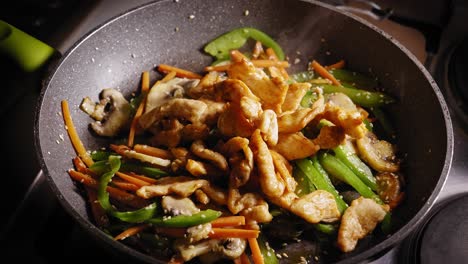 Adding-Chicken-Breast-Pieces-to-Frying-Pan,-Stirring-in-Pan,-Asian-Food