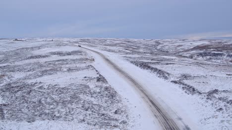 North-York-Moors-snow-scene,-slow-drivet-into-path-of-car-traversing-snow-covered-moors-road-in-winter