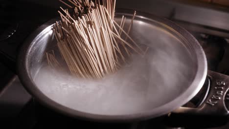 Adding-Japanese-Soba-Noodles-to-Hot-Water,-Making-Asian-Noodle-Dish