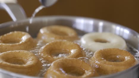 Close-up-of-flipping-perfectly-browned-homemade-donuts-in-hot-oil
