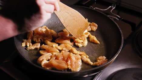 Frying-Chicken-on-a-Frying-Pan,-Stirring-with-Wooden-Spoon,-Japanese-food