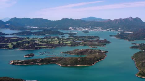 Aerial-truck-right-of-High-Island-Reservoir-verdant-islets-and-hills-surrounded-by-turquoise-water,-San-Kung-Peninsula-in-Hong-Kong,-China