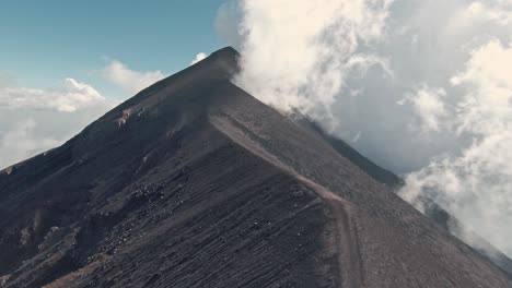 Steep-ridges-of-Fuego-volcano-slopes-and-peak,-aerial-FPV-flying-upwards