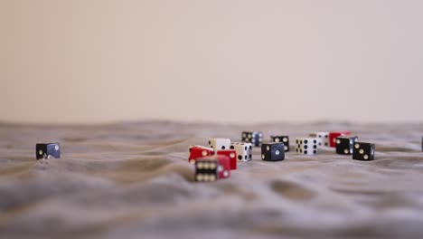 Rolling-red-dice-softly-onto-a-pile-of-other-dives-in-extreme-slow-motion