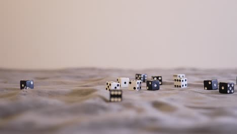 Rolling-five-black-dice-onto-a-gray-felt-table-with-white-dice