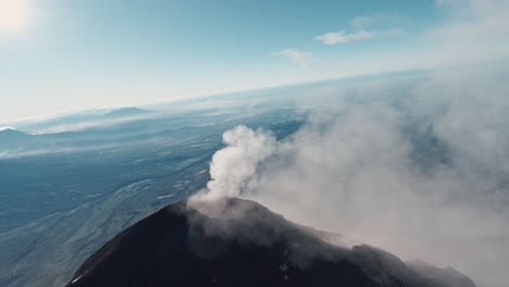 Smokes-rapidly-burst-from-volcano-peak-in-Guatemala,-aerial-FPV-view