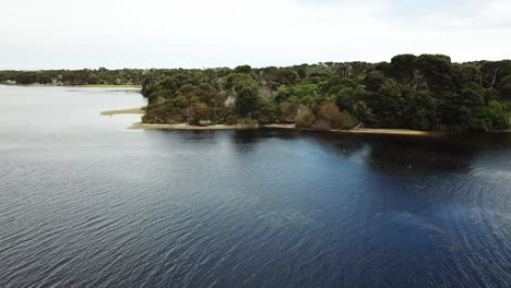 Drone-aerial-over-lake-and-nature-reserve-panning-and-going-backwards