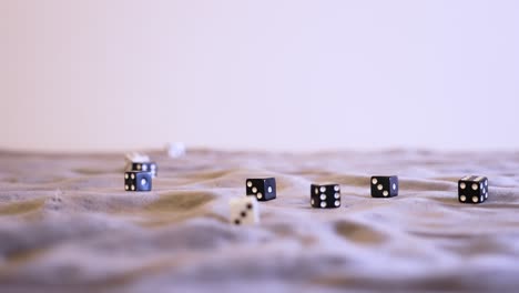 Rolling-black-and-white-dice-together-onto-grey-felt-in-extreme-slow-motion