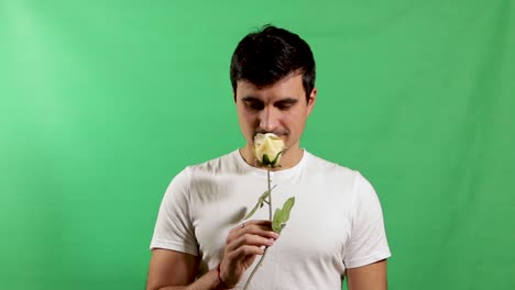 Handsome-young-adult-giving-rose-flower-isolated-on-green-screen