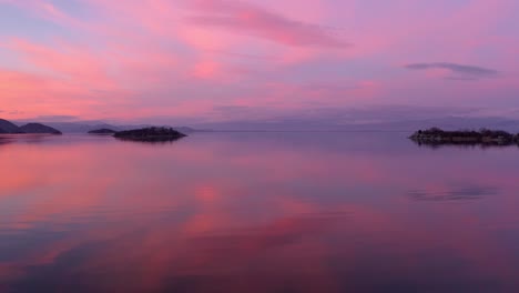 Stunning-landscape-shot-of-orange-and-purple-sunset-reflecting-in-lake
