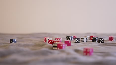 Pink-dice-in-a-pastel-shade-resting-among-red,-black,-and-white-dice