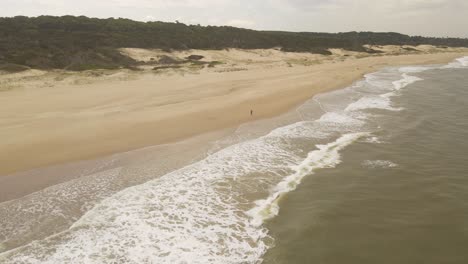 Man-Running-On-Playa-Grande-Beach-In-Punta-Del-Diablo,-Uruguay