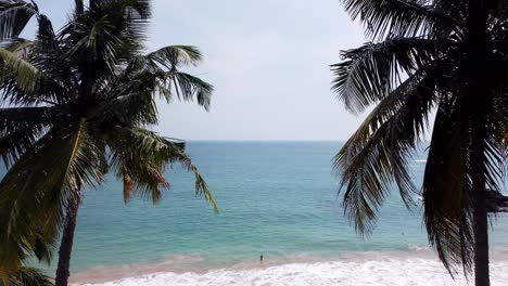 Drohne-Fliegt-Vorwärts-Zwischen-Zwei-Kokospalmen-Zum-Wunderschönen-Blauen-Ozean,-Mirissa,-Sri-Lanka