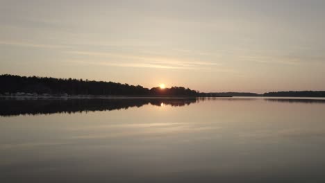 Sun-setting-down-on-the-horizon-water-reflection,-Sweden-natural-landscape