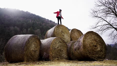 young-athletic-male-hike-hay-bales-in-remote-rural-mountain-farm,-off-grid-successful-happy-life-style-in-wilderness