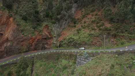 Auto-Fährt-Bergab-Durch-Den-Bergpass-Im-üppigen-Grünen-Madeira,-Seitenansicht