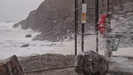 Snow-Blown-By-Strong-Wind-With-Waves-Crashing-On-The-Rocks