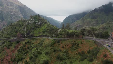 Encumeada-panoramic-mountain-pass-road-on-steep-ridge-in-Madeira,-cloudy-day,-aerial