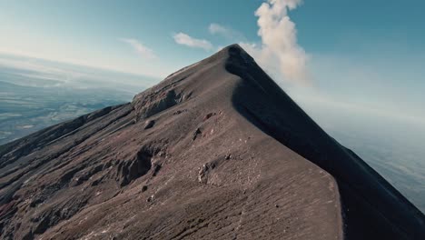 Fuego-volcano-peak-and-mountain-ridges-in-Guatemala,-aerial-FPV-view