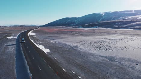 Autocaravana-Moderna-Conduciendo-Por-Una-Carretera-En-Llanuras-Montañosas-Nevadas-En-Islandia
