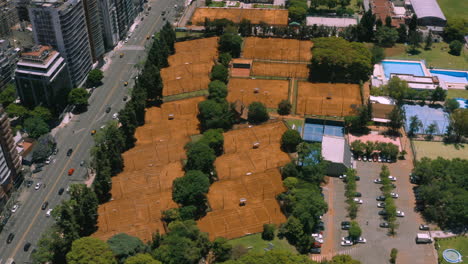 AERIAL---Tennis-courts-at-Club-Ciudad-de-Buenos-Aires,-Argentina,-approach-tilt-down
