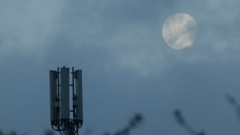 Cloud-passing-moon-behind-cellular-telecommunication-transmission-tower-antenna