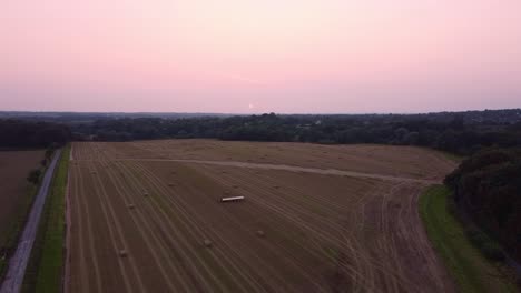 Drohnenschuss,-Der-Bei-Sonnenuntergang-Ein-Großes-Heufarmfeld-Schwenkt