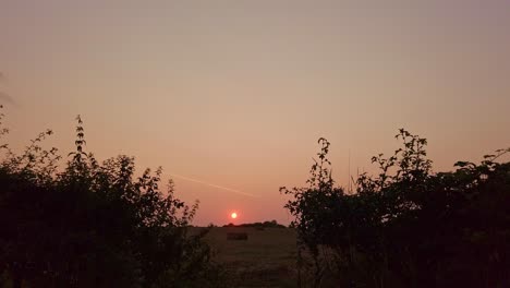 Gleitschuss-Eines-Bauernhoffeldes-In-Der-Abenddämmerung-Mit-Blick-In-Einen-Sonnenuntergang