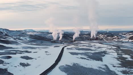 Smoking-geothermal-plant-in-frozen-volcanic-landscape,-Krafla,-Iceland