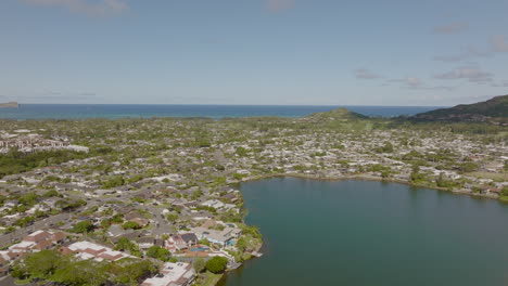 Aerial-of-Kailua-neighborhood-on-island-of-Oahu-in-Hawaii-on-a-beautiful-day-with-Ka'elepulu-pond-in-the-foreground-and-the-Pacific-Ocean-on-the-horizon