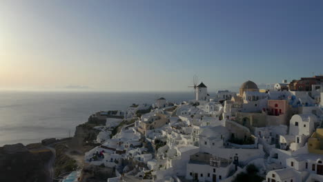 Straight-line-drone-shot-of-Oia-in-Santorini,-Greece-during-sunset