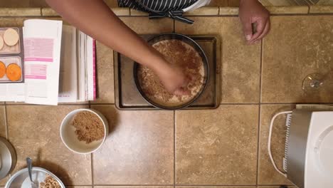Adding-crumble-to-the-top-of-a-homemade-vegan-coffee-cake---overhead-time-lapse