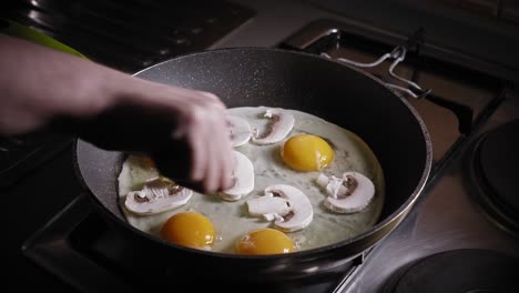 Huevos-Con-Rodajas-De-Champiñones-Cocinados-En-Una-Sartén,-Agregando-Aguacate-Picado