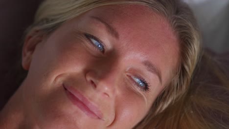 Pretty-blue-eyed-blond-woman-opening-eyes-waking-up-lying-in-bed,-fair-skin-caucasian