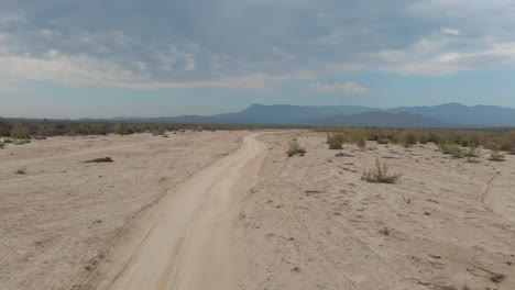 Establishing-drone-shot-of-dirt-road-and-mountains-in-rural-Mexico
