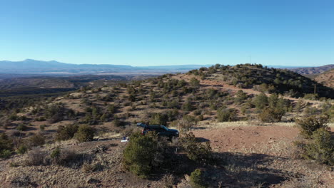 Aerial-orbits-4x4-vehicle-parked-on-scenic-overlook-in-desert-during-winter