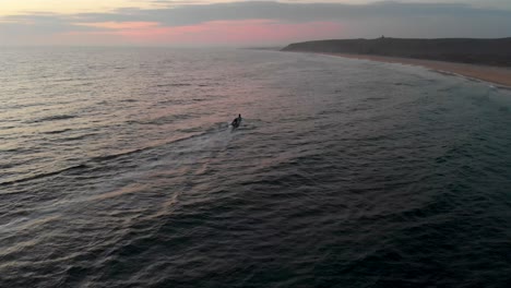 Small-fishing-boat-at-sunset-in-rural-Mexico-ocean-drone-establishing-shot-4k