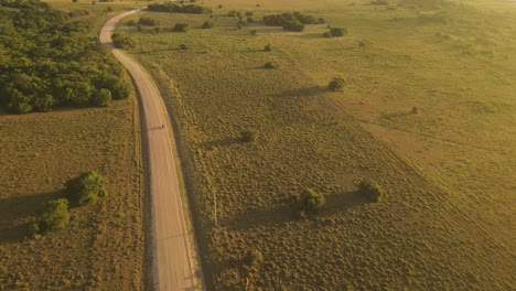 Aerial-view-of-motorcycle-on-country-road-during-sunset