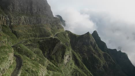 Winding-panoramic-captivating-auto-route-through-scenic-mountains-in-Madeira,-dreamy-sunlight,-aerial