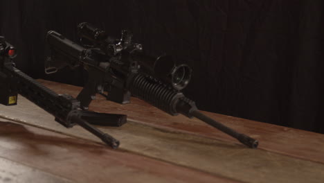 Dolly-out-of-two-AR-15-rifles-standing-on-a-wooden-table