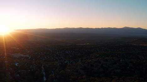 Scenic-aerial-view-of-sunset-desert-landscape-with-car-parked-on-overlook,-4K