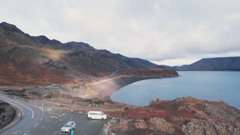 Campercar-parking-by-a-road-on-a-cliff-above-Kleifarvatn-lake,-Iceland