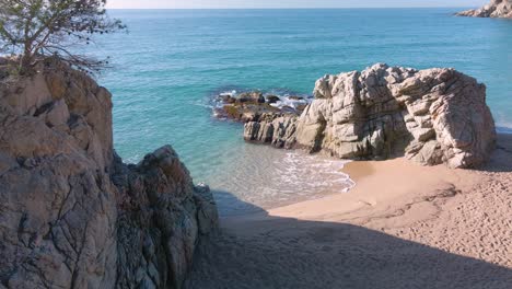 Close-up-of-the-rocks-on-the-Costa-Brava-beach-with-turquoise-water-and-transparent-calm-sea