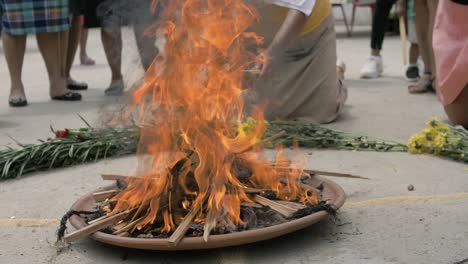 Mayan-religious-ritual-performed-with-sacred-fire-offering-surrounded-by-flowers-and-other-elements---Slow-Motion