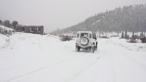 Land-Rover-Defender-D90-Driving-Through-Snowy-Back-Country-Road-In-Alpine-Rocky-Mountains-Valley-Near-Nederland-Boulder-Colorado