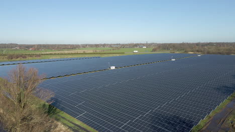High-angle-view-of-large-solar-panel-field-in-a-rural-area-with-a-white-truck-driving-in-the-background